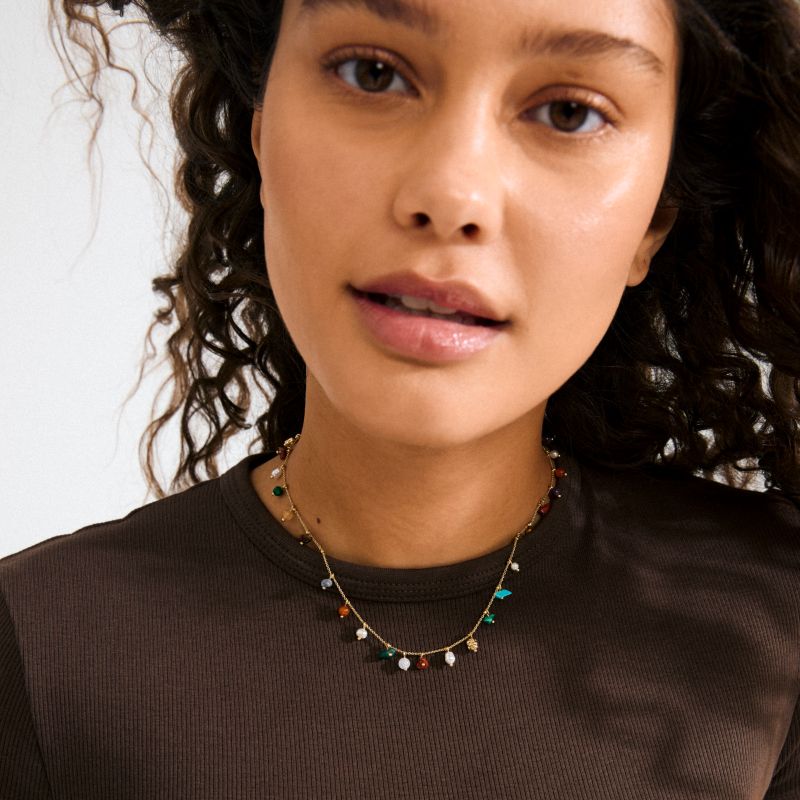 pilgrim between gold coloured necklace